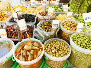 Many different olives, dried fruits on the market close-up