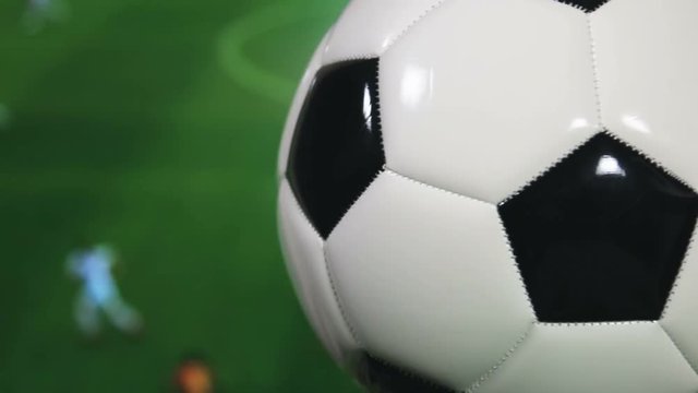 the soccer ball is spinning on the background of the football match. Leather soccer ball in classic coloring