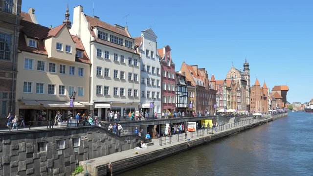 Center embankment with people tourists walk, restaurants and beautiful facades of buildings Gdansk Poland