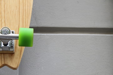 particolare di skateboard con ruote verde appeso alla parete