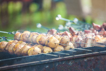 Baked potatoes on skewers on the grill