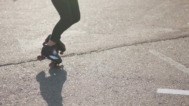 Attractive beautiful young woman riding roller skating and dancing in the streets. Urban background, slow motion 120fps