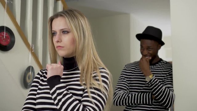 Young Couple Wearing Same Outfit Getting Laughed At. Handheld Shot Of White Girlfriend Being Laughed At By Black Boyfriend Indoors - Wearing Matching Outfits