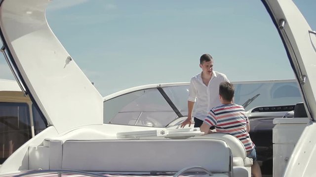 Handsome guy discuss with salesman some details of yacht rent