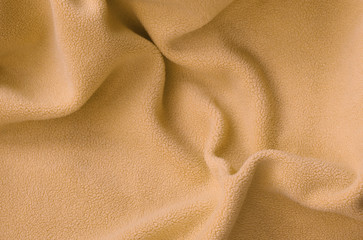 The blanket of furry orange fleece fabric. A background of light orange soft plush fleece material...