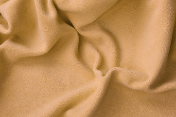 The blanket of furry orange fleece fabric. A background of light orange soft plush fleece material...