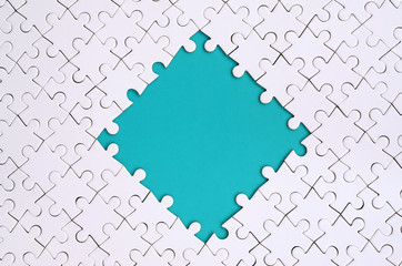 Framing in the form of a rhombus, made of a white jigsaw puzzle around the blue space