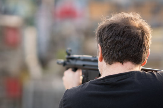 Back turned caucasian man taking aim at the target with a sniper rifle