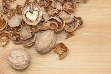 Walnut and shells on wooden background. nuts in shape of heart
