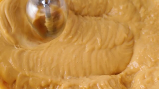 Close slow motion video of mixing butterscotch pudding
