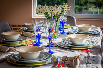 The closeup shot of wedding reception dinner table setup with the empty glasses of wine and water, spoon, fork and napkin, The flowers use for decoration.