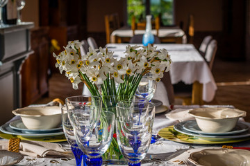 The closeup shot of wedding reception dinner table setup with the empty glasses of wine and water, spoon, fork and napkin, The flowers use for decoration.