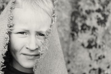 The head portrait of a poor boy. Head in a sackcloth. Emotions.