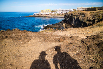 View to the Callao Salvaje village and rocs on seaside. Shadows of two people on the ground.