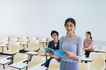 Young woman standing present friend student in a classroom showing ready answer. concept of education.