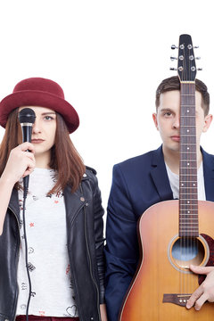 Musical artists sing and play acoustic guitar.