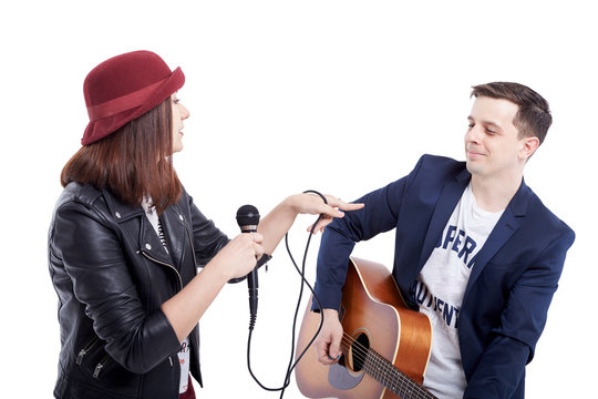 Musical artists sing and play acoustic guitar.