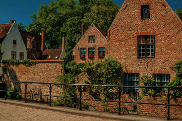 Old brick houses and greenery on the canal's edge at Bruges. With many canals and old buildings, this graceful town is a World Heritage Site of Unesco. Northwestern Belgium. Retouched photo