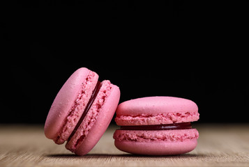 Two pink macaroons on wooden background