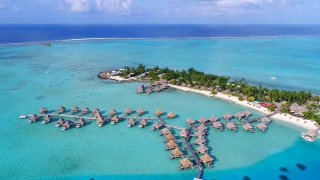 Aerial view of tropical paradise of Bora Bora island, turquoise crystal clear water of scenic blue lagoon, typical over water bungalows, Matira Point - South Pacific Ocean, French Polynesia from above
