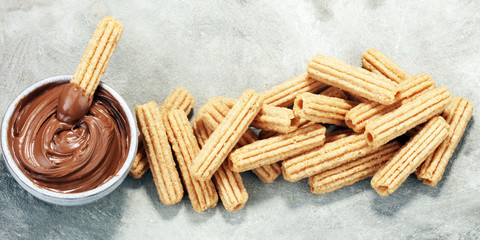 Traditional Spanish dessert churros with sugar and chocolate