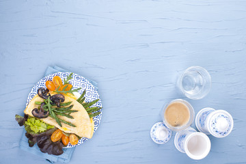 Healthy breakfast. Omelette with asparagus, mushrooms and salad. Vegan. Copy space . A glass with a fragrant black coffee. view from above