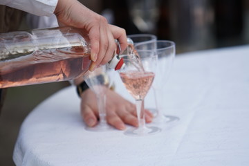 Beautiful row line of different colored alcohol cocktails on a party, martini, vodka,and others on decorated catering bouquet table on open air event, picture with beautiful bokeh