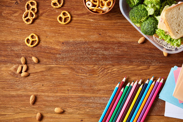 A notebook, two markers and assortment of cookies on a wooden table, copy space for text, selective focus.