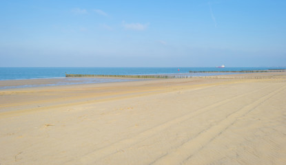 Fototapeta na wymiar Recreational beach along the North Sea below a blue sky in spring