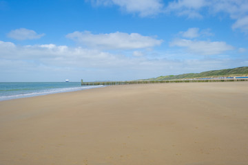 Beach cabins along hilly dunes on a recreational beach in sunlight in spring
