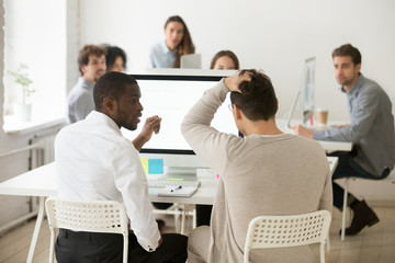 Rear view of stressed businessman suddenly realized problem mistake using pc with colleague in...