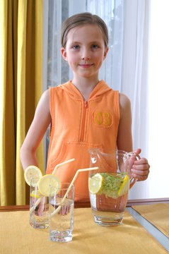 Drink of elderflowers and lemon - girl helps in the kitchen