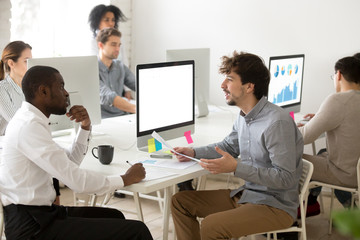 Obraz premium Mentor teaching african new hire making notes in office, multiracial colleagues discussing explaining new idea brainstorming at workplace, team leader giving corporate instructions to black manager