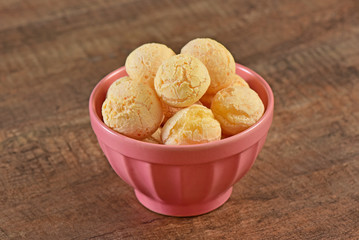 Cheese breads on pink bowl and wooden background