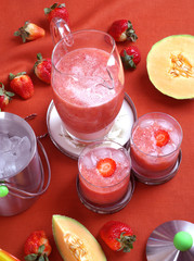 Pink cocktail with strawberries and melon