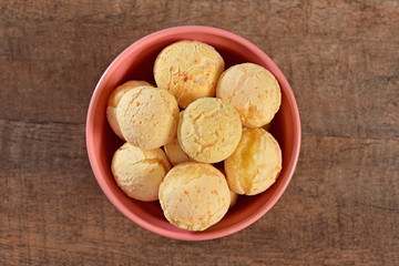 Cheese breads on pink bowl and wooden background
