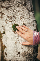 stylish traveler girl holding hand on birch bark in sunny forest and mountains. happy earth day concept. travel and wanderlust concept. space for text. environment protection