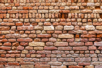Old vintage brickwall built by random pattern with different sizes of bricks