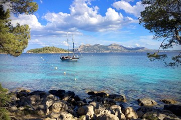 sailing boat on a crystal clear blue ocean at Playa de Formentor, Mallorca, Spain