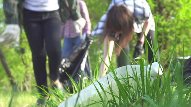 volunteers and teen girl collect garbage in plastic bags concept