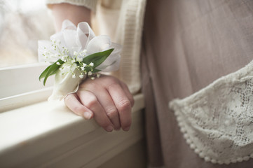 Midsection of girl wearing ribbons and flower decoration on wrist at home