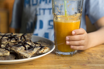 child drinking ornage juice