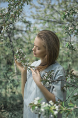 Beautiful girl in a spring blooming garden. The concept of youth, beauty