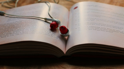 Close up of an old book and earphones 
