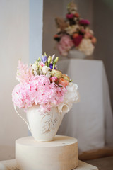 Dining table setting at Provence style, with candles, lavender, vintage crockery and cutlery, closeup. Beautiful wedding decoration with flowers pink violet purple white colors