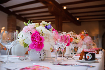 Dining table setting at Provence style, with candles, lavender, vintage crockery and cutlery, closeup. Beautiful wedding decoration with flowers pink violet purple white colors