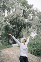 woman with white headscarf in the forest, has cancer