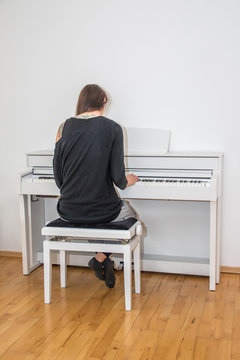 Junge Frau spielt digitales Klavier daheim