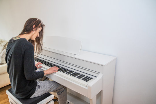 Junge Frau spielt zu Hause Digitalpiano
