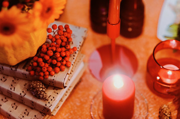 Autumn wedding decoration with flower composition with roses, chrysanthemum, maple leaves, pumpkin, books and candles. Haloween concept